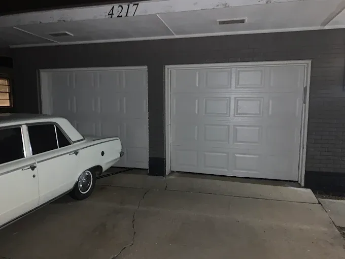Two single-car white garage doors on residential home by Affordable Door Co OKC